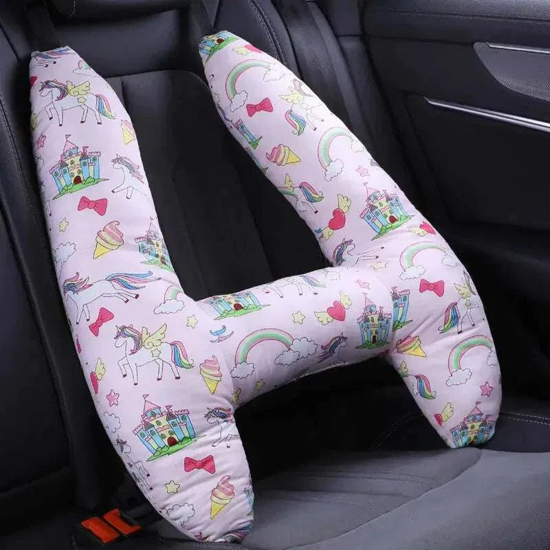 Kids car travel pillow with unicorn and rainbow design in a car seat.