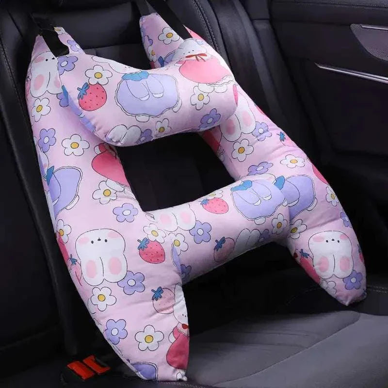 Kids car travel pillow with colorful cartoon design on car seat.