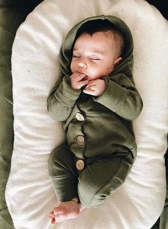 Baby sleeping in a green hooded romper with button closure, designed for comfort and style.