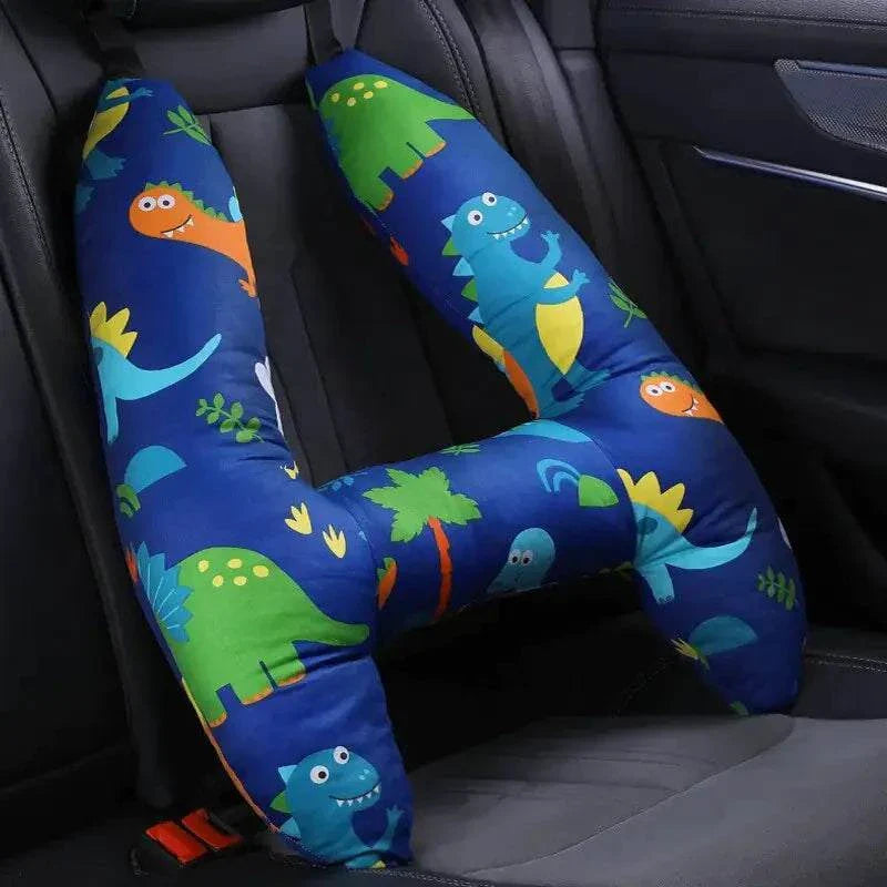 Colorful kids car travel pillow with dinosaur print on a car seat.