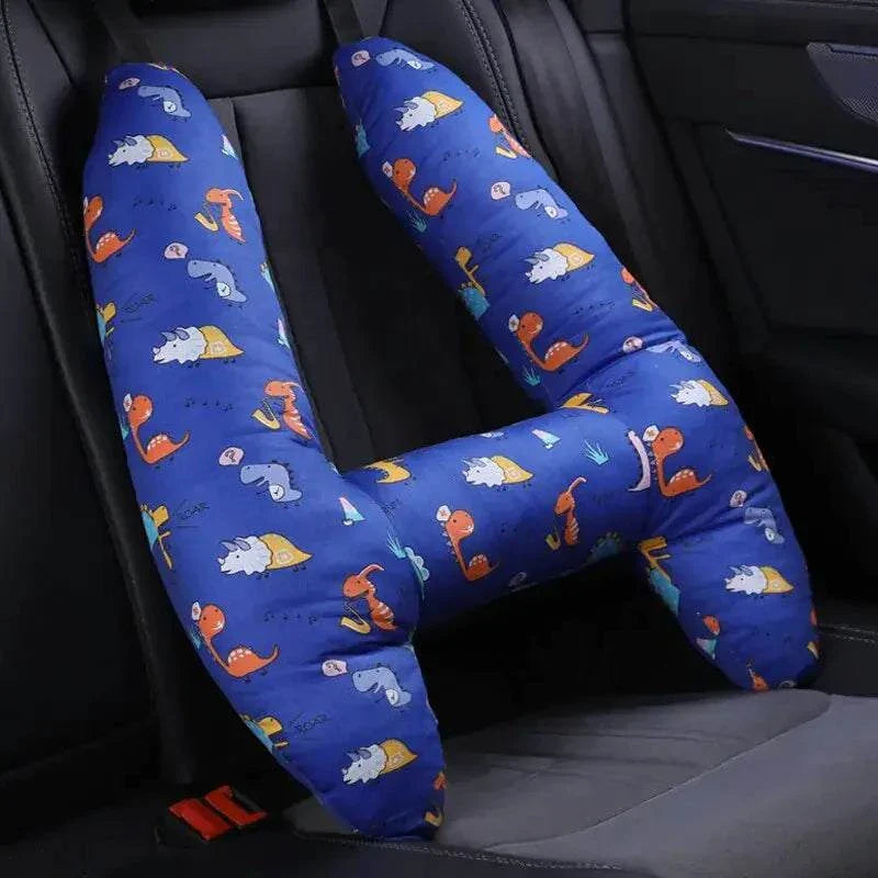 Kids car travel pillow with colorful dinosaur print on car seat.