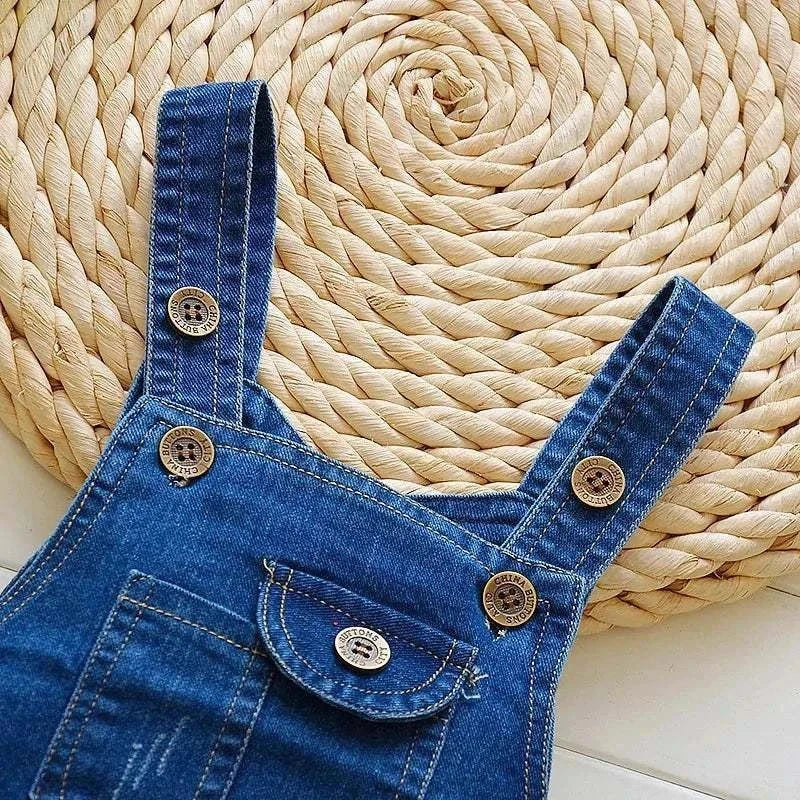 Toddler boys' denim overalls jeans jumpsuit with button details on woven mat background.