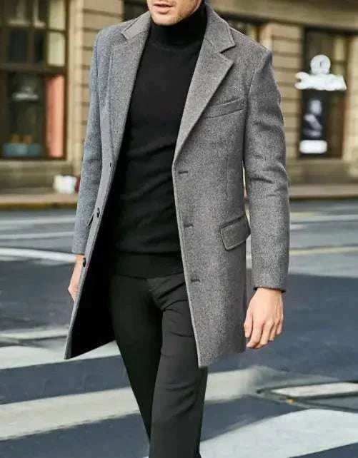 Men's long sleeved woolen coat in charcoal grey, featuring a tailored fit and notch lapel, worn in a city setting.