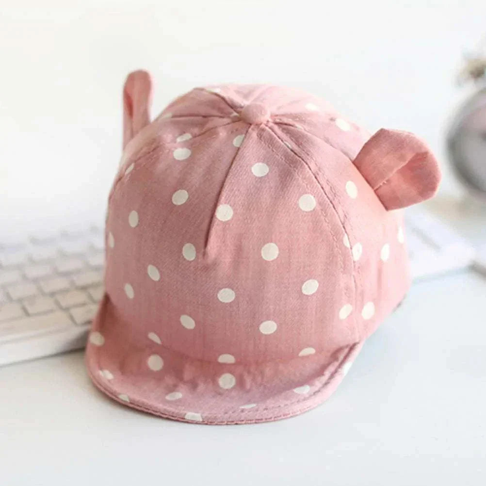 Toddler sun hat with cute dots, pink with ear flaps, provides sun protection.