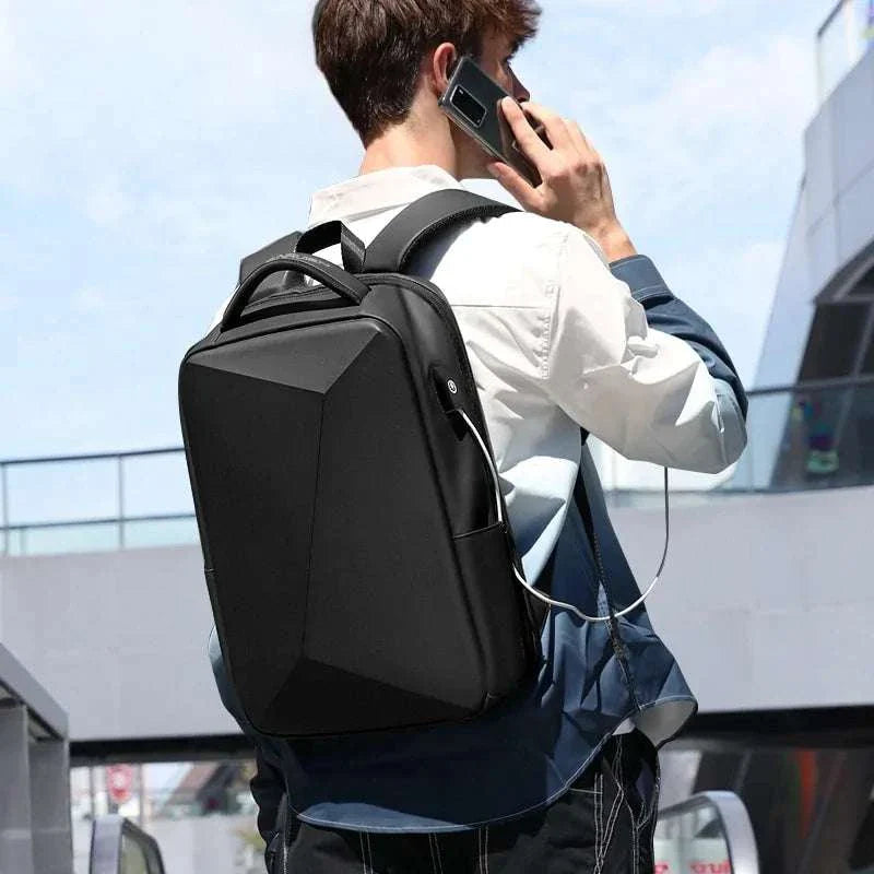 Man carrying a sleek black anti-theft laptop backpack with USB charging port on a city street.